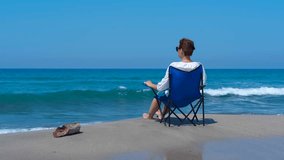 A woman enjoys solitude on the shore of the blue sea. Woman sits on a beach chair, enjoying a tranquil day at the beach. Gentle waves crash on the shore, creating a peaceful atmosphere - Powered by Shutterstock - Get 15% off with code: PIKWIZARD15