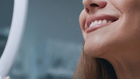A young woman is smiling while sitting in a dental chair. The dentist is preparing for a routine check-up, ensuring a comfortable environment. The clinic features a clean and modern design, cropped - Powered by Shutterstock - Get 15% off with code: PIKWIZARD15
