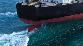 Stern of a large cargo ship or tanker navigating through open sea. Ship's rudder is visible, creating white foam and wake water as it moves. Deck equipped with industrial equipment, including winches
 - Powered by Shutterstock - Get 15% off with code: PIKWIZARD15
