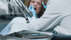 A dentist is examining a patient's teeth in a contemporary dental clinic. The patient is seated in a dental chair while tools are organized on a tray nearby, showcasing a focus on oral healthcare. - Powered by Shutterstock - Get 15% off with code: PIKWIZARD15