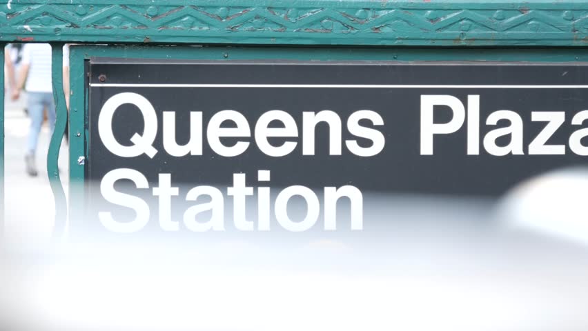 New York subway sign, Queens underground metro station. Metropolitan entrance fence, public transport exit. Long Island city street, NYC United States. Navigation text on signboard. Pedestrians people