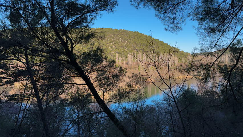 Moving shot of the river Krka from dense forest with mountain in the background. Krka National Park, Croatia