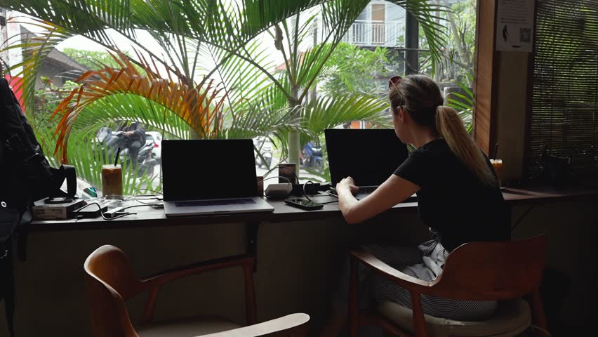 Digital nomad woman working with laptop in a coffee shop in Bali - Coworking space concept