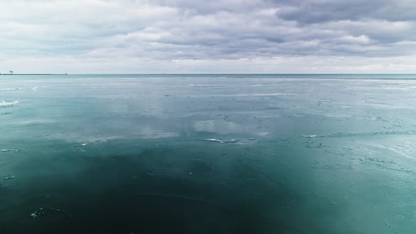 Harmony of sky and water, frozen Lake Michigan surface reflecting clouds