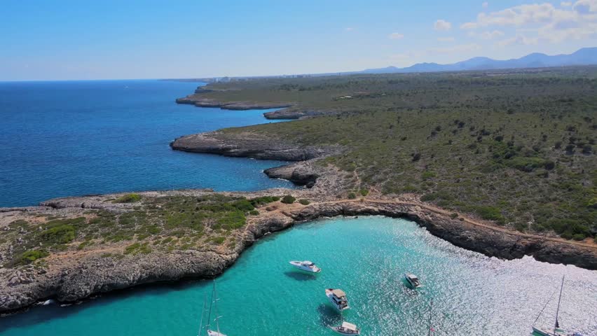 Cala Varques offers breathtaking views of turquoise waters and a rugged coastline in Majorca. Enjoy the serene beauty and tranquil atmosphere as boats glide through the bay.