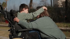 Mother hugging disabled son in wheelchair at park - Powered by Shutterstock - Get 15% off with code: PIKWIZARD15