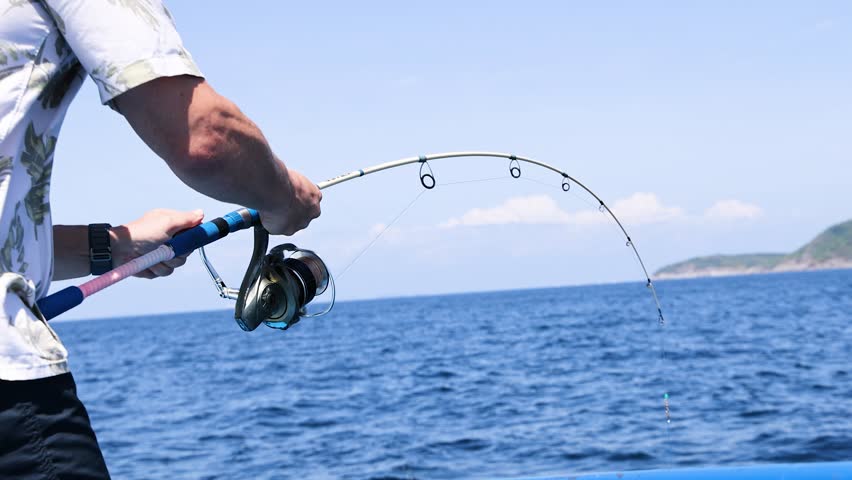 Angler reeling in catch on a boat