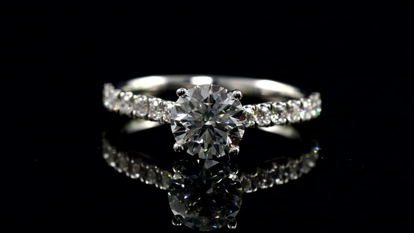 beautiful bright and shine diamond ring on the mirror with black background. solitaire diamond ring