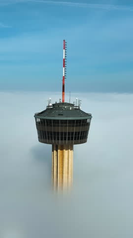 Vertical drone shot around the Tower of the Americas, misty sunrise in San Antonio