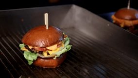 Cooking process A chef at the grill adds crispy bacon to a burger with cheese and lettuce. Perfect for video content about cooking, food blogs or restaurant menus. - Powered by Shutterstock - Get 15% off with code: PIKWIZARD15