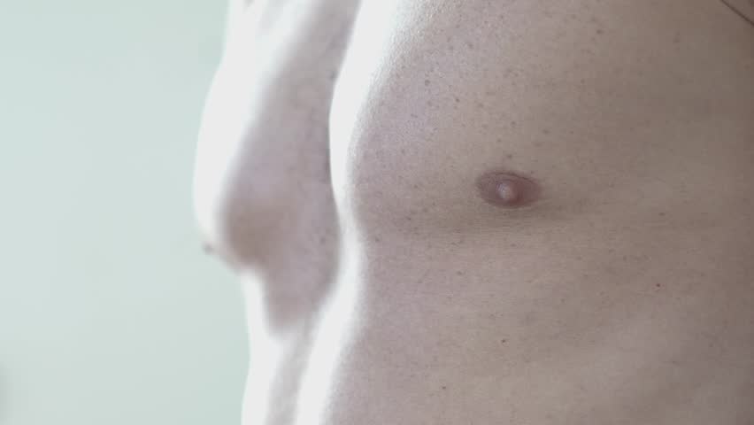 Close-up shot of a muscular male athlete revealing his pectoralis muscles