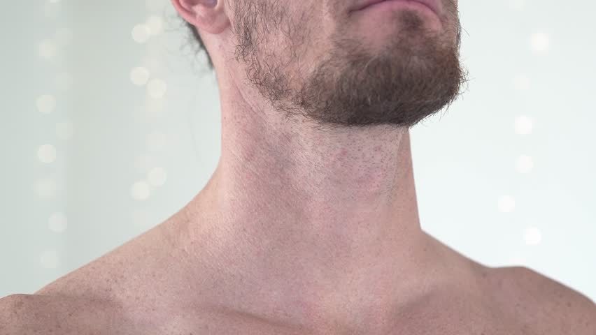 Close-up shot of a topless man feeling his carotid pulse with his fingers