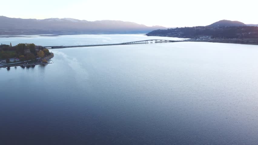 Kelowna Sunset, Downtown Waterfront Landscape of Entire City. British Columbia, BC Interior, Canada. Calm Okanagan Lake. Evening Sunset, City Park Walking Path, Yacht Club, Marina, Sail Statue.