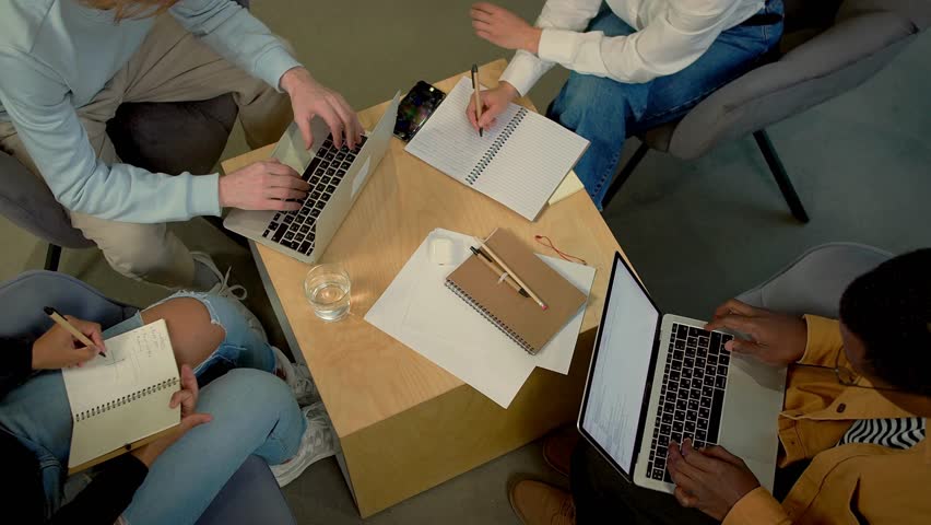 Students collaborating on projects in a cozy study space with laptops and notebooks - Powered by Shutterstock - Get 15% off with code: PIKWIZARD15