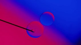  drops from a needle on a blue-red gradient background. High resolution footage 4k. - Powered by Shutterstock - Get 15% off with code: PIKWIZARD15