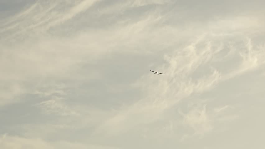 A model of an airplane controlled by a remote control flies in the sky. flying club. A hobby for a man.