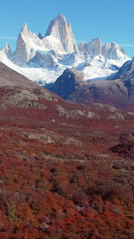 Dramatic Mount Fitz Roy in Patagonia, near Argentinian town of El Chaltén; vertical aerial flying over autumn vegetation
