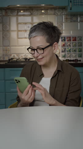 Mature Woman Showing Vertical Green Screen Cellphone at Camera and Giving Thumbs Up