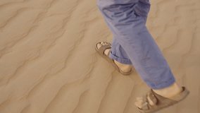Walking on sand in Oman, capturing feet in sandals leaving footprints behind - Powered by Shutterstock - Get 15% off with code: PIKWIZARD15
