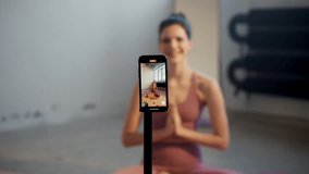 Engaged Woman Actively Practicing Yoga While Using Smartphone for Live Virtual Class - Powered by Shutterstock - Get 15% off with code: PIKWIZARD15