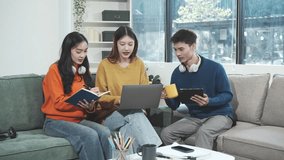 Three Asian young adult students sit in university living room, discussing their study abroad experiences, academic research, preparing thesis report, planning future global education opportunities. - Powered by Shutterstock - Get 15% off with code: PIKWIZARD15