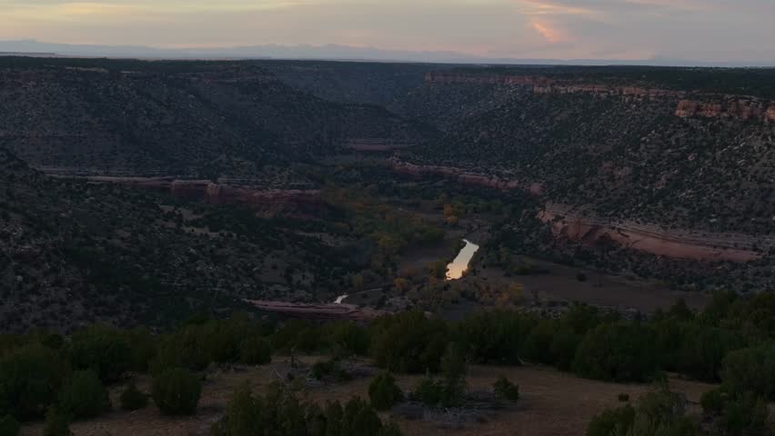 Misty canyon landscape with a river reflecting light at sunset, Mills Canyon, New Mexico