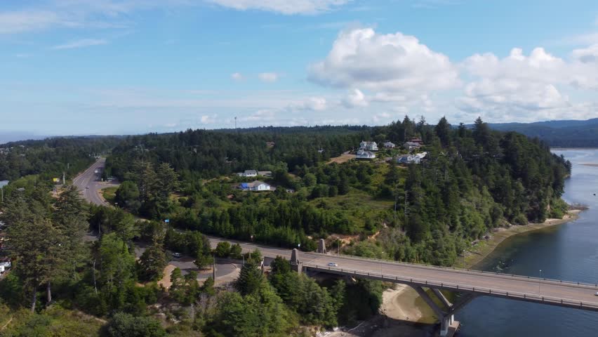 Cars Driving Across Bridge Crossing on Summer Day. Alsea Bay Bridge spanning the Alsea River in Waldport, OR, Oregon, along Highway 101. Cars Driving South Towards Yachats and Florence