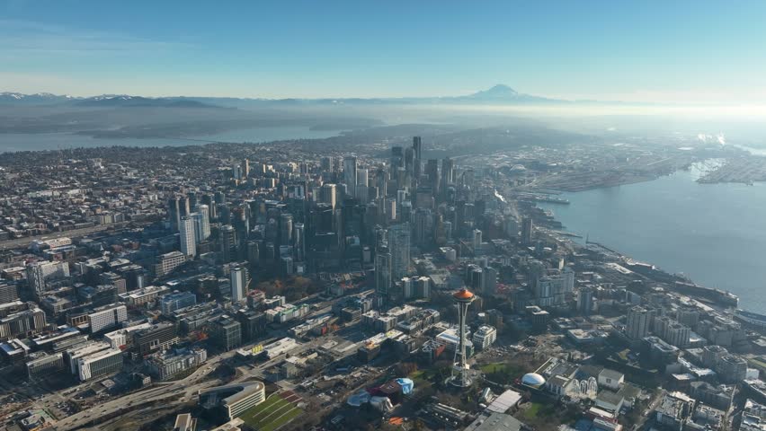 High altitude aerial of Seattle cityscape, Elliot Bay, Mt Rainer with blue sky