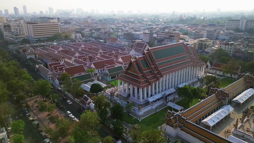 Aerial static establishing of Wat Suthat temple complex in Bangkok, Thailand, architectural details and surrounding cityscape