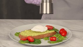A woman with an electric mill prepares savory toasts with avocado, poached egg - Powered by Shutterstock - Get 15% off with code: PIKWIZARD15