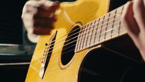 Young musican man checking strings of acoustic guitar close-up. Male guitarist tuning sound of musical instrument.  - Powered by Shutterstock - Get 15% off with code: PIKWIZARD15