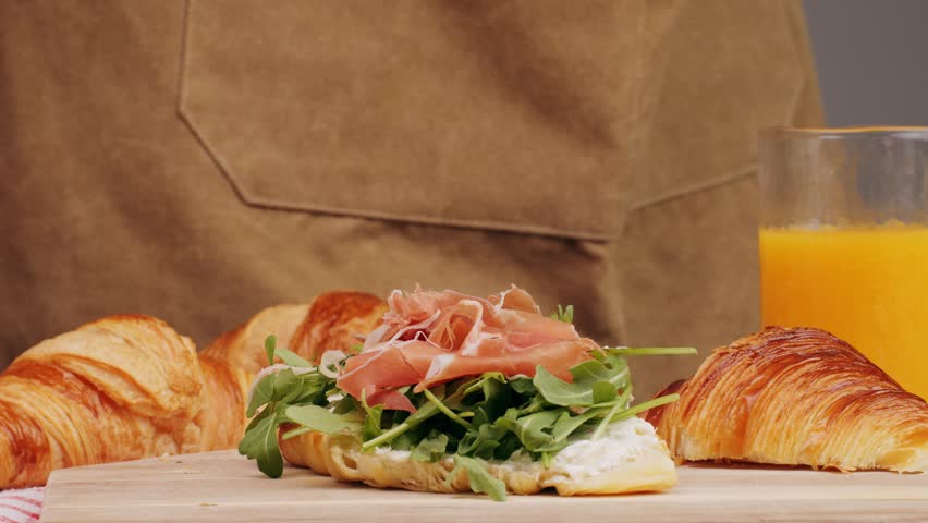  Croissant with jamon ham, Salmon, in Modern Cafe, Top View of Healthy Breakfast in Cafe. English breakfast: fried egg, bacon toast on sandwich.