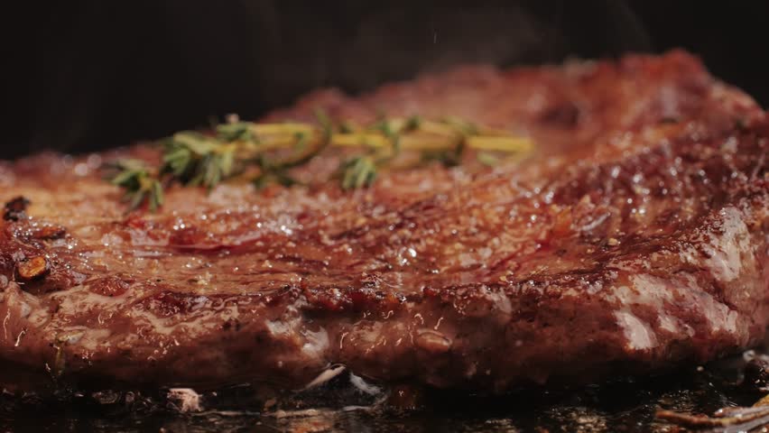Fresh marbled beef with pepper, salt and rosemary close-up macro. Cooking juicy steak on grill with oil. Premium organic wagyu meat