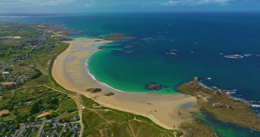 Aerial view of the tranquil beach at Plage des Amiets with clear turquoise water and waves