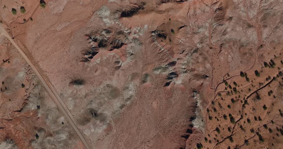 Rocky desert terrain in New Mexico with a dirt road and scattered shrubs