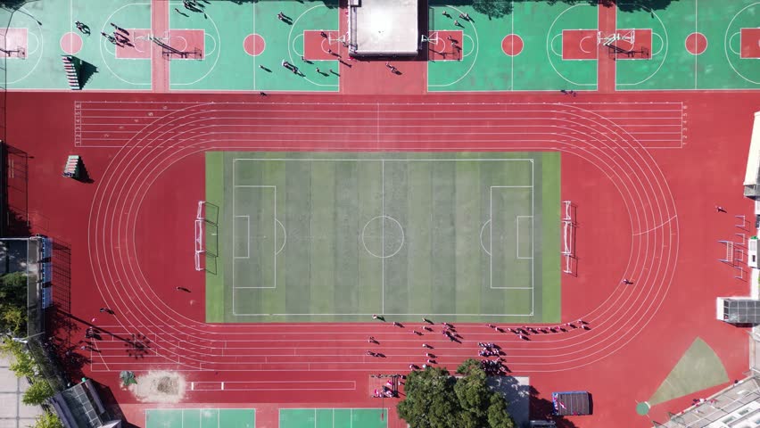 Aerial view of students exercising on a sports field, vertical overhead angle