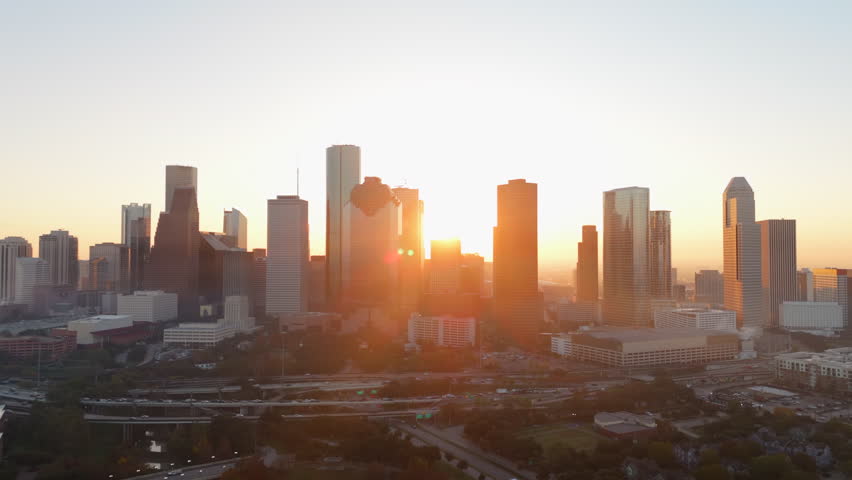 Aerial view of Downtown Houston, Texas showcases impressive and towering skyscrapers set against a breathtaking and vibrant sunset, effectively capturing the true essence of this dynamic urban city