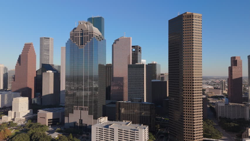 Breathtaking aerial drone shot captures stunning and vibrant skyline of Downtown Houston, beautifully highlighting iconic skyscrapers set against a lively and energetic city atmosphere. Texas, USA