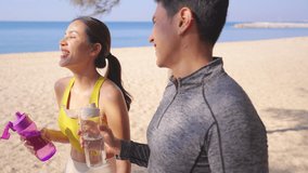 Healthy Asian man and woman do sport training jogging exercise at tropical beach. Couple drinking water from reusable plastic bottle after workout running at seaside. Wellness healthcare motivation. - Powered by Shutterstock - Get 15% off with code: PIKWIZARD15