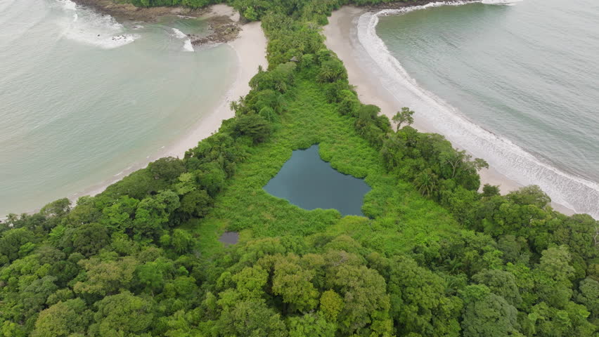 Experience a breathtaking aerial view of Playa Manuel Antonio, featuring its lush greenery and stunningly beautiful beaches within Costa Ricas national park