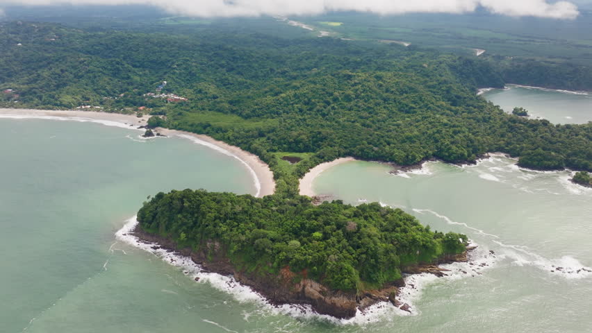Admire the aerial view of Playa Manuel Antonio in Manuel Antonio National Park, with lush greenery, diverse wildlife, and beautiful sandy beaches