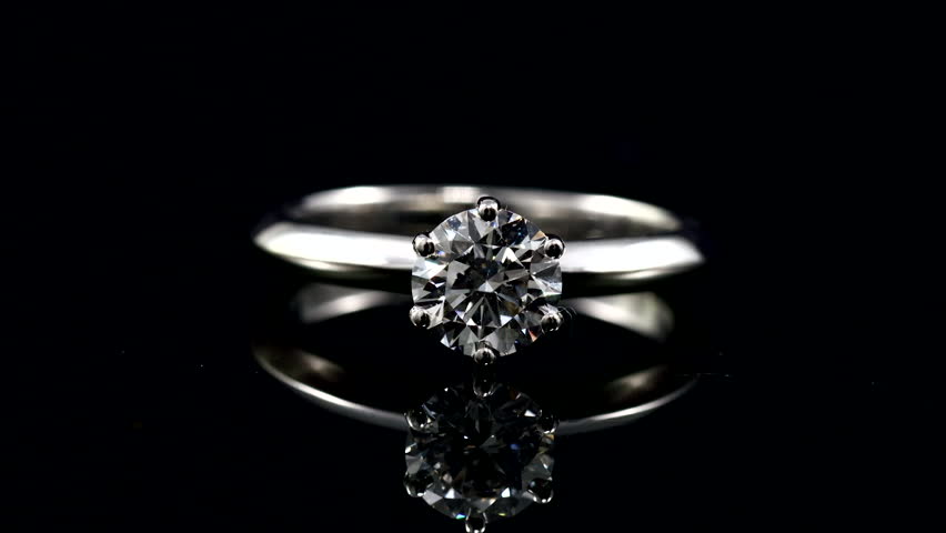 beautiful bright and shine diamond ring on the mirror withh black background. solitaire diamond ring