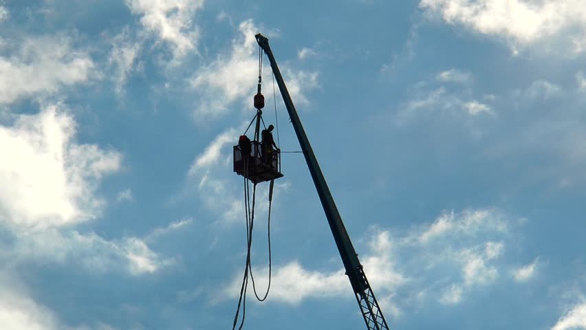 A daring young man bungee jumps and soars against an evening sky with golden glowing clouds on a summer sunny and cloudy evening.