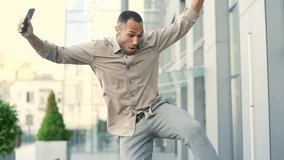 Excited handsome employee jumps and rejoices get good news great result looking at mobile phone. Young adult business male celebrating success walking near office building outside browsing smartphone - Powered by Shutterstock - Get 15% off with code: PIKWIZARD15
