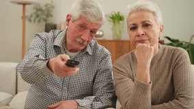Happy old family at home. Senior couple husband wife watching TV relaxing on sofa in living room. Old mature family enjoying weekend together. Grandparents watching television. Leisure activities - Powered by Shutterstock - Get 15% off with code: PIKWIZARD15