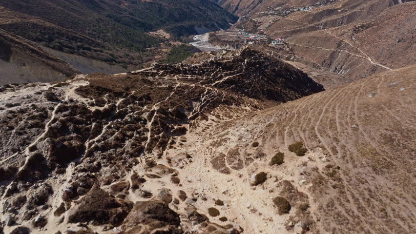 Aerial panorama revealing sweeping Himalayan valley nestled beneath Mount Everest, showcasing dramatic rugged Nepalese mountain terrain