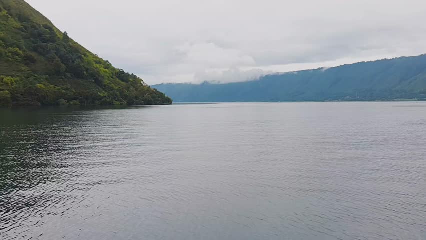 panoramic lakeside view of a slow-moving boat