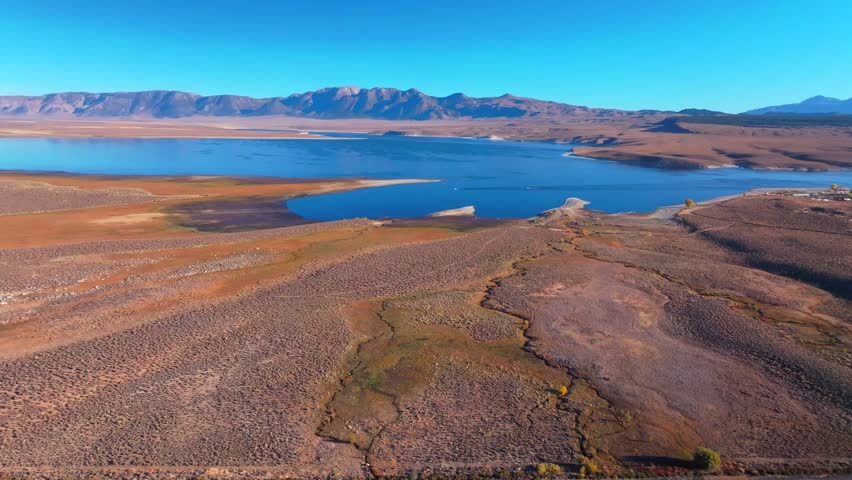 Calm Crowley Lake Stone Columns Marina boats fishing Mammoth Lakes Mountain California aerial drone October Fall autumn morning blue sky Bishop Toms Place Sierra hilltop hot springs forward motion