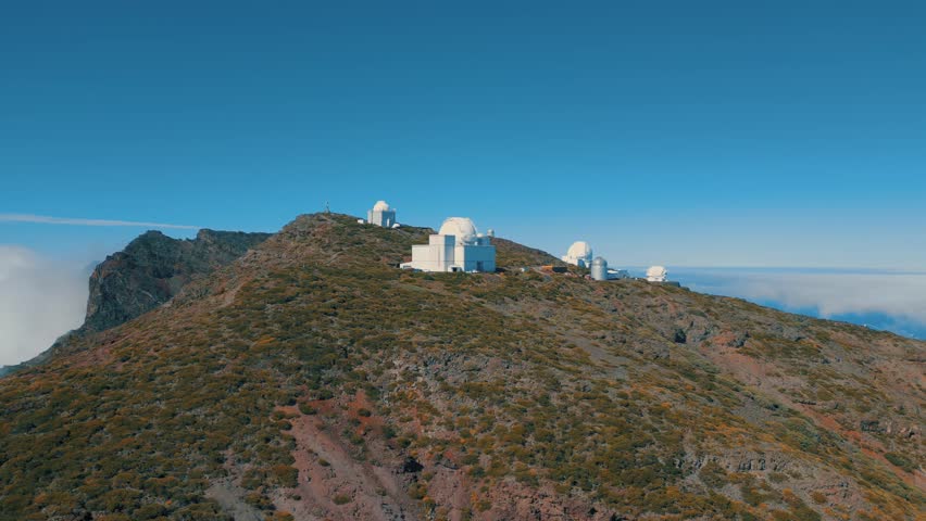 A breathtaking view of the Roque de los Muchachos Observatory, located atop La Palma, featuring panoramic scenes of clouds near the Caldera de Taburiente National Park.