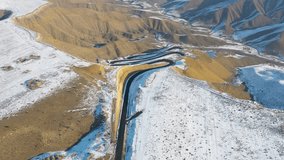 Aerial drone 4K footage of a snowy winding mountain road and pass near Azat Reservoir, Armenia, leading to Garni. The Martian-like landscape contrasts with the snow, creating a surreal winter scene - Powered by Shutterstock - Get 15% off with code: PIKWIZARD15